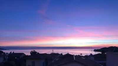 a sunset over the roofs of houses in a city at Suggestivo appartamento in Saint-Jean-Cap-Ferrat
