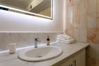 a bathroom with a sink and a mirror and towels at Studio Premium au Calme avec Terrasse Vue Mer et Parking in Nice