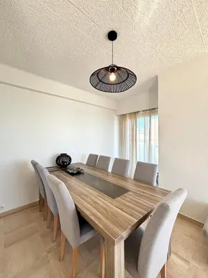 a dining room with a wooden table and chairs at NICE, Exceptional Sea View, Top Floor, Parking in Nice