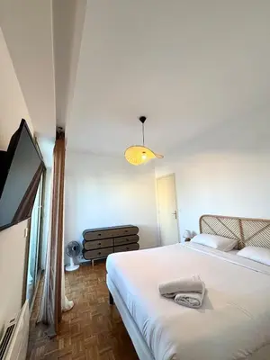 a bedroom with two beds and a flat screen tv at NICE, Exceptional Sea View, Top Floor, Parking in Nice