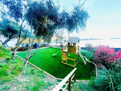a small playground in a garden with a tree at Sublime villa d'architecte, piscine et parking in Nice