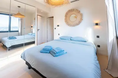 a bedroom with a large bed with blue towels on it at Sublime villa d'architecte, piscine et parking in Nice