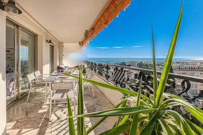 a balcony with a table and chairs and the ocean at La Casa Azzura in Nice