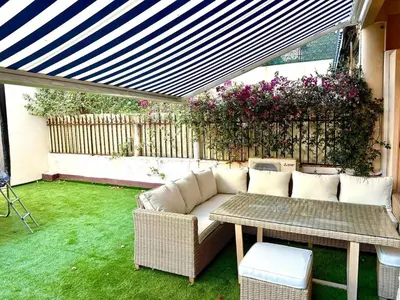 a patio with a couch and a table in a yard at Wonderful apartment and garden heart of Nice in Nice
