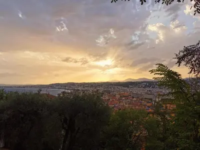 a view of a city with the sunset in the background at Wonderful apartment and garden heart of Nice in Nice