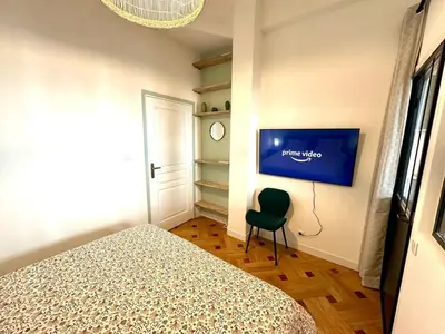 a bedroom with a bed and a tv on the wall at Wonderful apartment and garden heart of Nice in Nice