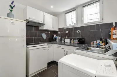 a white kitchen with a sink and a refrigerator at Nice Renting - 5b PENCHIENATTI - Charming Cozy Studio Balcony AC Massena in Nice