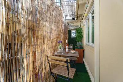 a room with a bench and a wall with a table at Nice Renting - 5b PENCHIENATTI - Charming Cozy Studio Balcony AC Massena in Nice