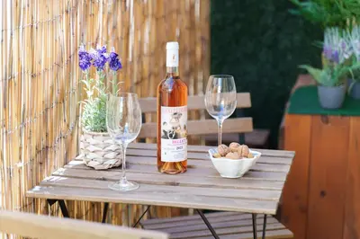 a bottle of wine and two wine glasses on a table at Nice Renting - 5b PENCHIENATTI - Charming Cozy Studio Balcony AC Massena in Nice