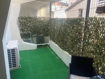 a balcony with green flooring and a green hedge at Studio 29 Nice Magnan in Nice