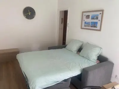 a bedroom with a bed and a clock on the wall at Studio 29 Nice Magnan in Nice