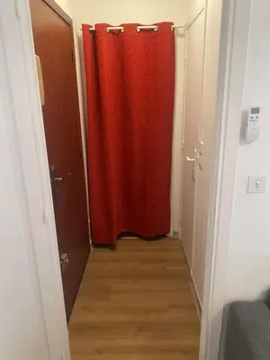 a red shower curtain in a hallway with a wooden floor at Studio 29 Nice Magnan in Nice