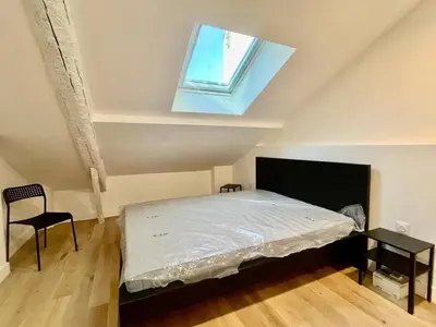 a bedroom with a bed with a window and a chair at Nice Signature Assalit 2P in Nice