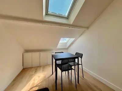 a table and chairs in a room with a window at Nice Signature Assalit 2P in Nice