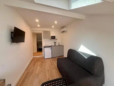 a living room with a couch and a kitchen at Nice Signature Assalit 2P in Nice