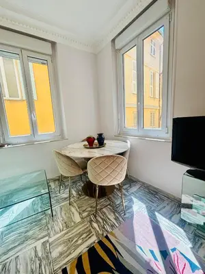 a room with a table and two chairs and two windows at Centre ville-vieille ville-promenade des Anglais in Nice