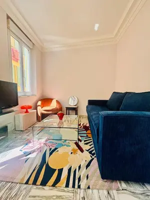 a living room with a blue couch and a glass table at Centre ville-vieille ville-promenade des Anglais in Nice
