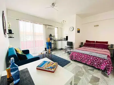 a bedroom with a bed and a living room at Cosy studio à 2 pas de la mer in Nice