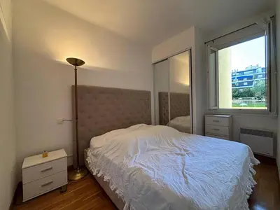 a bedroom with a bed and a large window at Nice Signature Halévy in Nice
