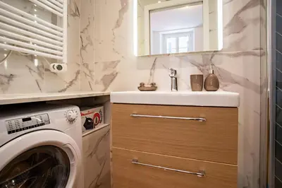 a bathroom with a sink and a washing machine at ICONIC AP4460 By Riviera Holiday Homes in Nice