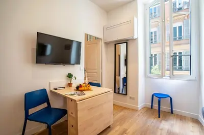 a room with a desk and two chairs and a tv at ICONIC AP4460 By Riviera Holiday Homes in Nice