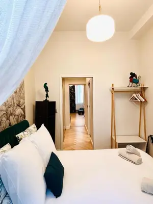 a bedroom with a white bed and a hallway at Old Town Vibes - 5min to Sea - AC & Breakfast in Nice