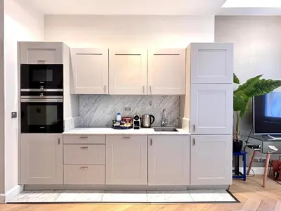 a white kitchen with white cabinets and a tv at Old Town Vibes - 5min to Sea - AC & Breakfast in Nice