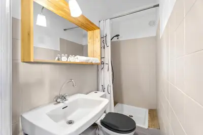 a bathroom with a sink and a toilet and a mirror at Studio Malaussena - Welkeys in Nice