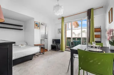 a bedroom with a bed and a table and a dining room at Studio Malaussena - Welkeys in Nice