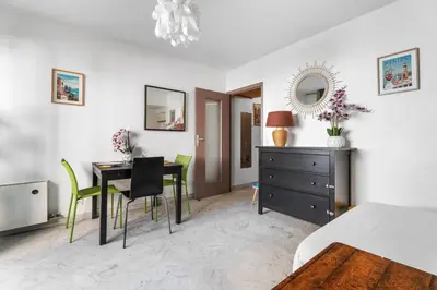 a bedroom with a bed and a table and chairs at Studio Malaussena - Welkeys in Nice
