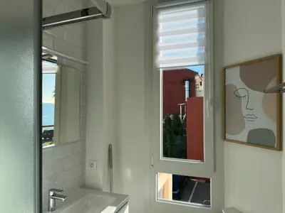 a bathroom with a sink and a window at Panoramic Sea View Studio in Cagnes-sur-Mer