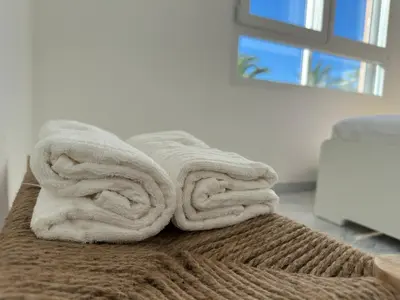 a pile of towels sitting on top of a bed at Panoramic Sea View Studio in Cagnes-sur-Mer
