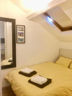 a bedroom with two beds and a mirror at Lumineux Studio dernier étage avec terrasse, proche mer in Nice