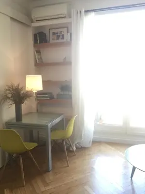 a dining room with a table and chairs and a window at Lumineux Studio dernier étage avec terrasse, proche mer in Nice