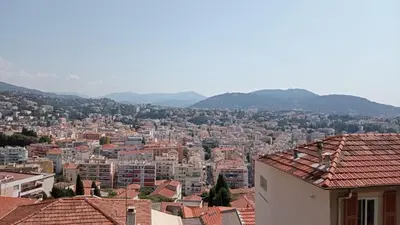 a view of a city with buildings and mountains at Magnifique 2 pièces in Nice