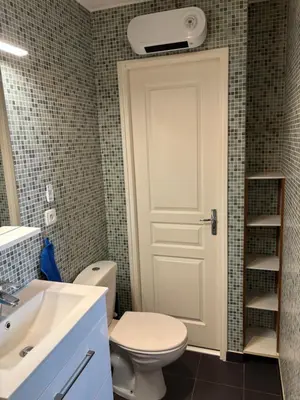 a bathroom with a toilet and a white door at Magnifique 2 pièces in Nice
