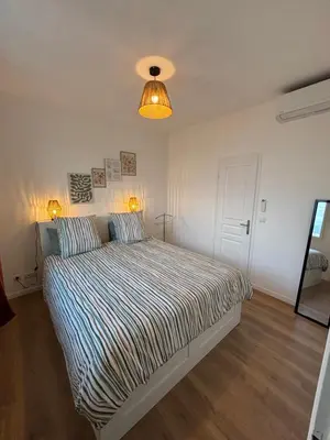 a bedroom with a bed and a light fixture at Magnifique 2 pièces in Nice