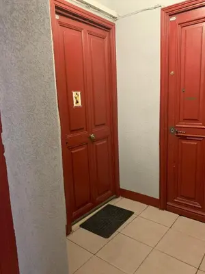 a hallway with two wooden doors and a tile floor at Port de nice in Nice