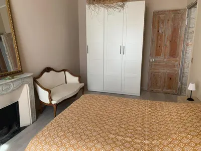a bedroom with a bed and a chair and a fireplace at Port de nice in Nice