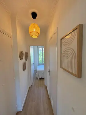 a hallway with a chandelier and a room with a bed at 2P Central Nice in Nice