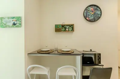 a kitchen with a counter with two chairs and a microwave at Nice Magnan studio avec jardin proche des plages in Nice