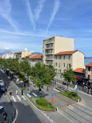 a city street with a building and a street with pedestrians at Comfy 2 min to Beach - AC in Nice