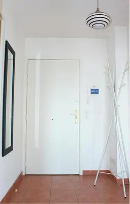 a large white door in a room with at Comfy 2 min to Beach - AC in Nice
