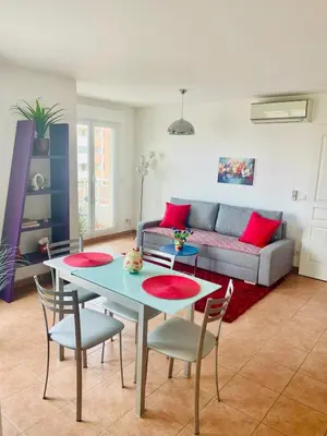 a living room with a table and chairs and a couch at Comfy 2 min to Beach - AC in Nice