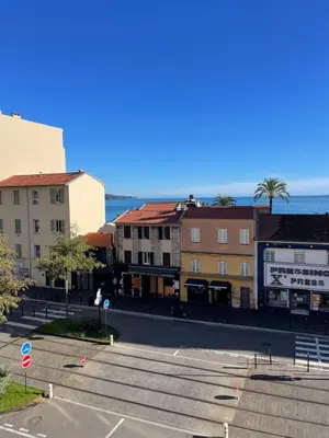 an empty street in a city with buildings and the ocean at Comfy 2 min to Beach - AC in Nice