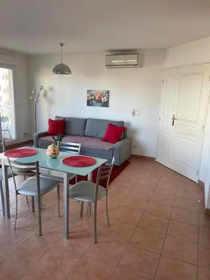 a living room with a couch and a table and chairs at Comfy 2 min to Beach - AC in Nice