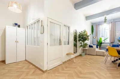 a living room with white walls and a large door at Boho Chic Apartment in Old Town in Nice