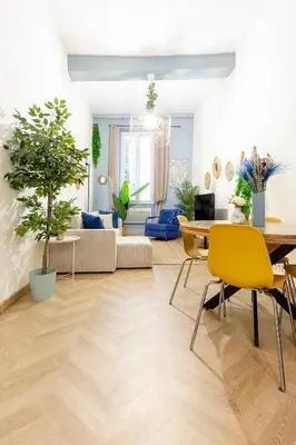 a living room with a table and yellow chairs at Boho Chic Apartment in Old Town in Nice