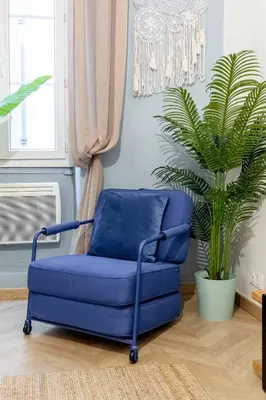 a blue chair in a room with a plant at Boho Chic Apartment in Old Town in Nice