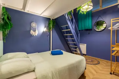 a bedroom with a bed and a blue wall at Boho Chic Apartment in Old Town in Nice